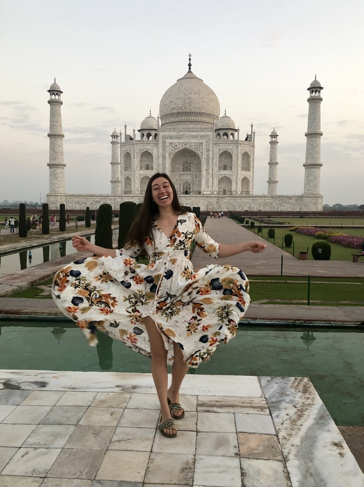 Femme sautant joyeusement devant le Taj Mahal.