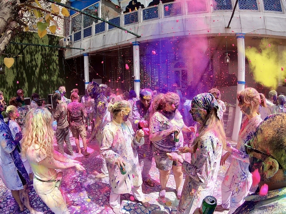 Des gens qui célèbrent avec des poudres colorées, probablement lors d'un festival.