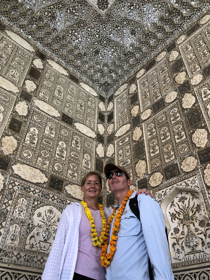 Two people standing inside a building with intricate patterns on the walls.