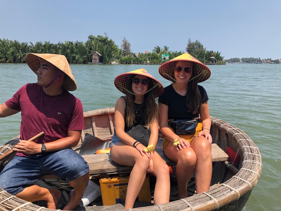 People in a small round boat wearing traditional hats.