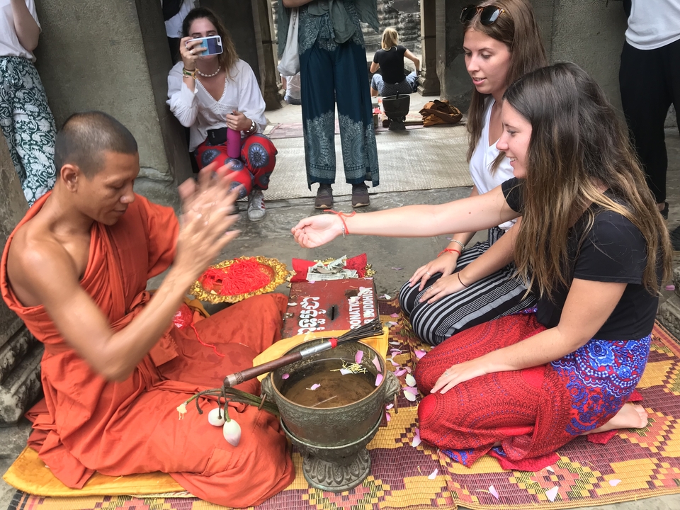 Monk blessing people at a temple.