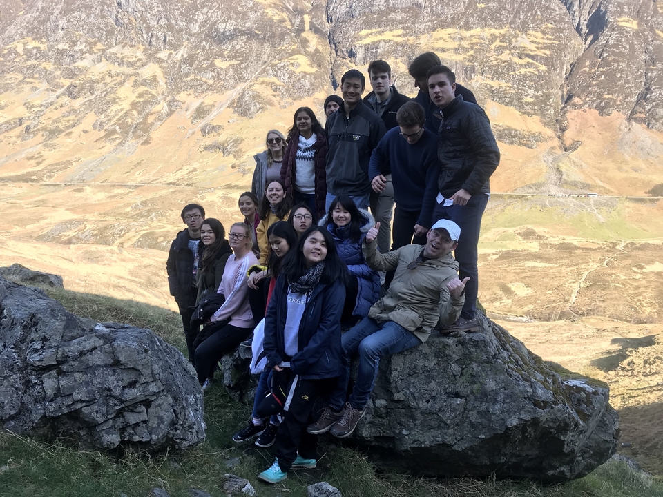 Group climbing rocks in mountainous terrain.