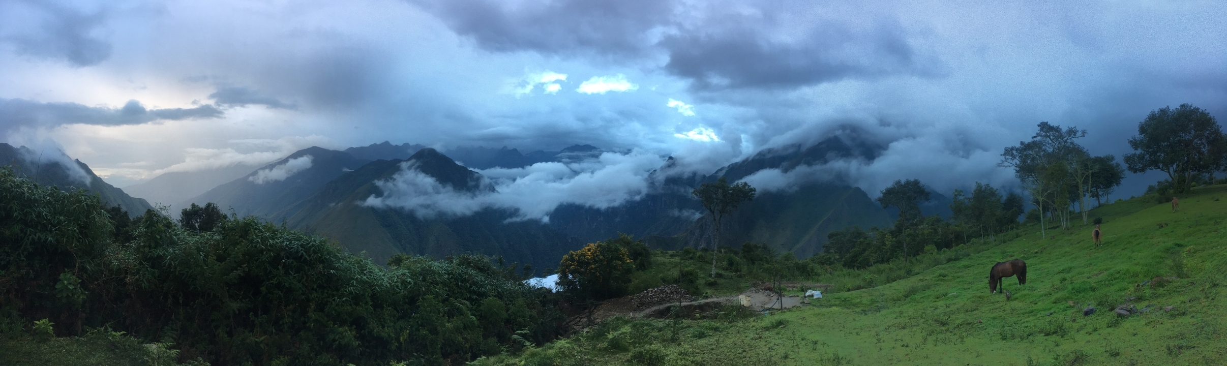 Clouds rolling over lush mountain landscape.