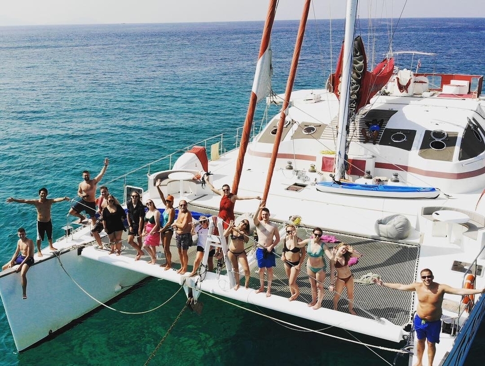 Groupe posant sur un catamaran dans l'océan.