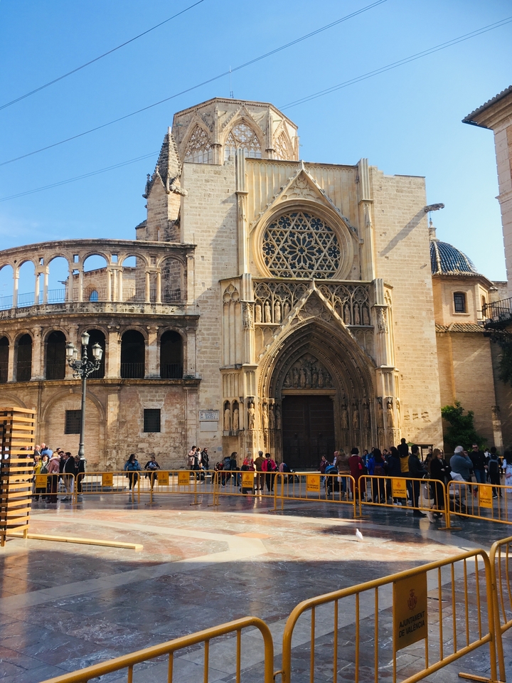 Gothic cathedral with an ornate facade in a busy plaza.