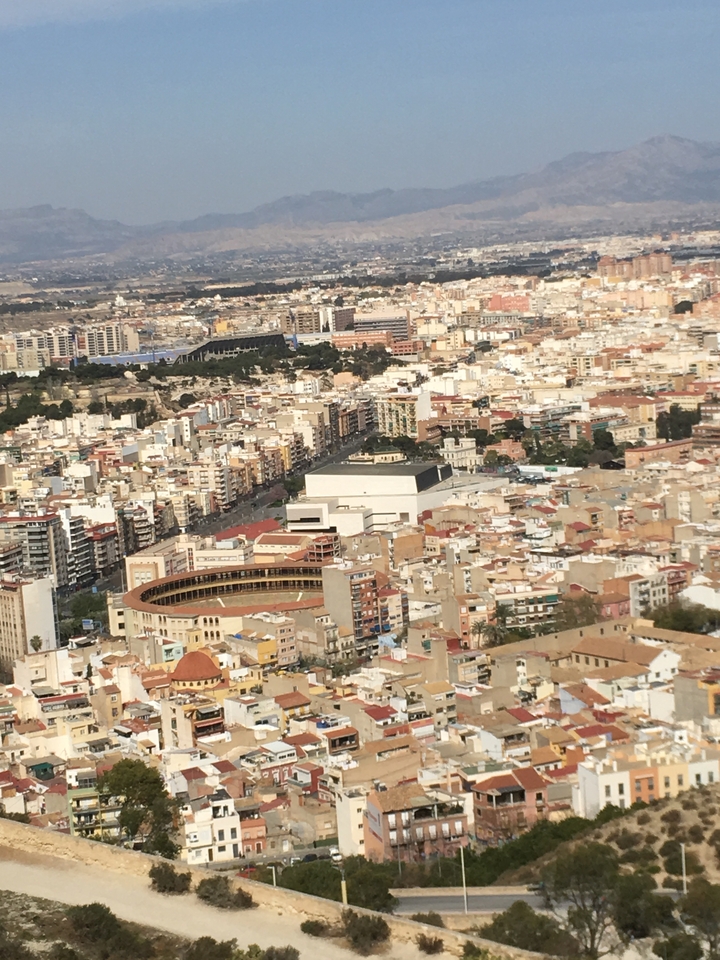 Urban landscape with a bullring and various buildings.