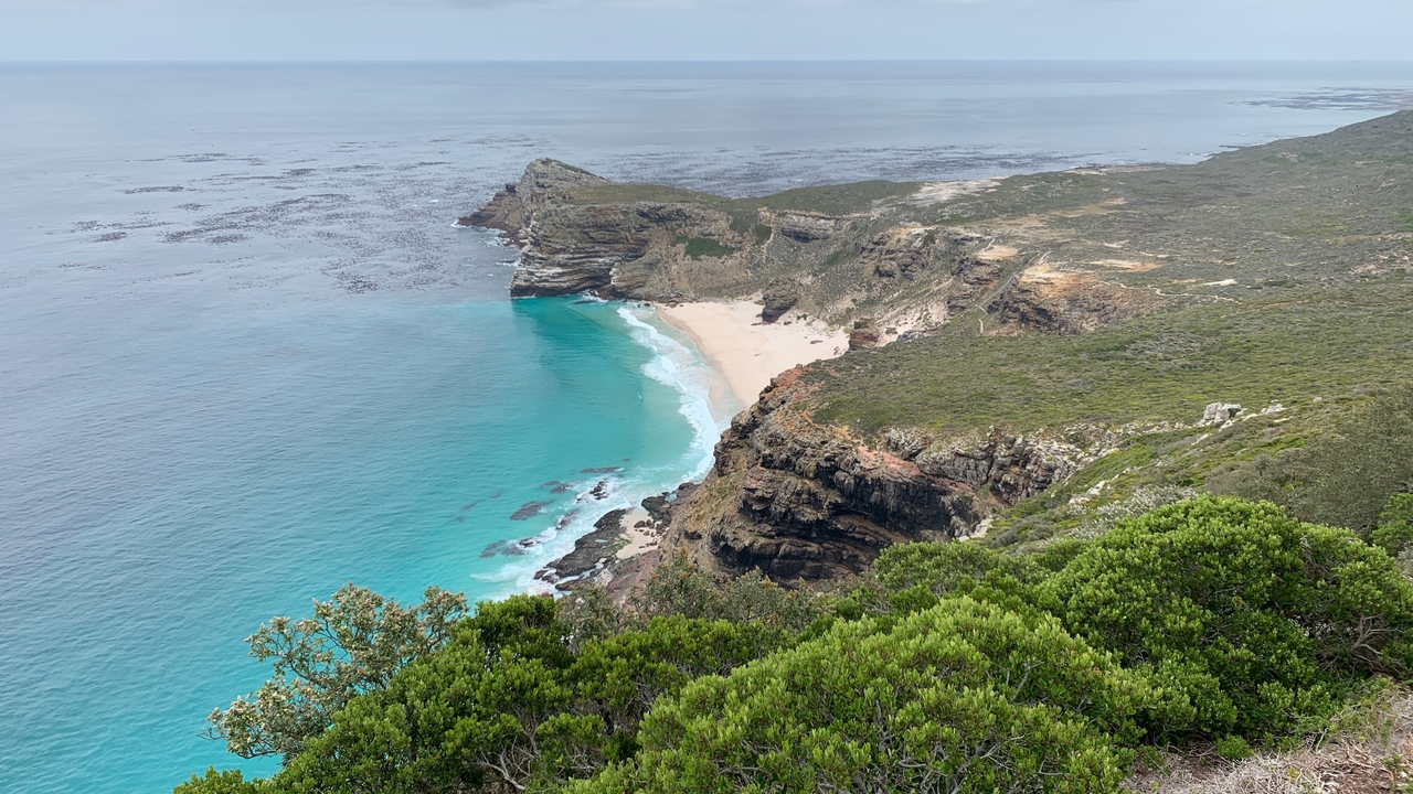 Magnifique paysage côtier avec une eau turquoise cristalline et une falaise.