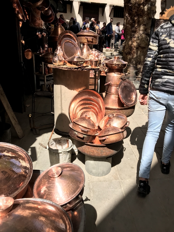 Close-up of copper kitchenwares in a market setting.