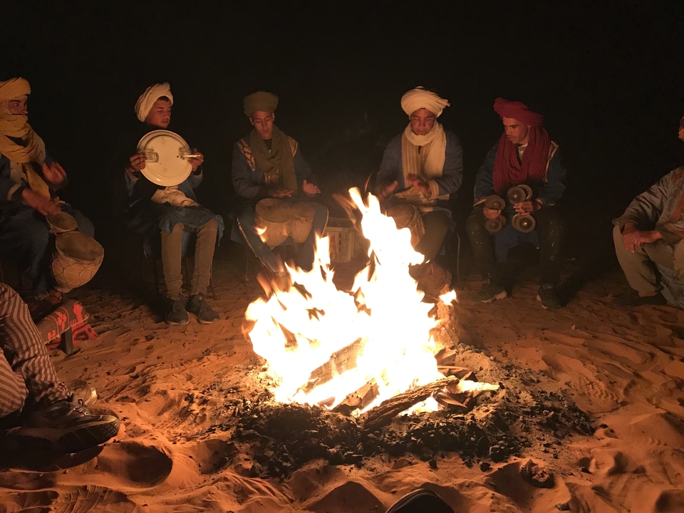 Group of people around a campfire at night.