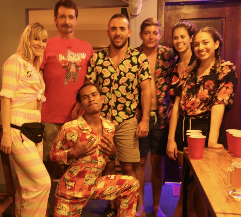 Group of people posing indoors with dim lighting.