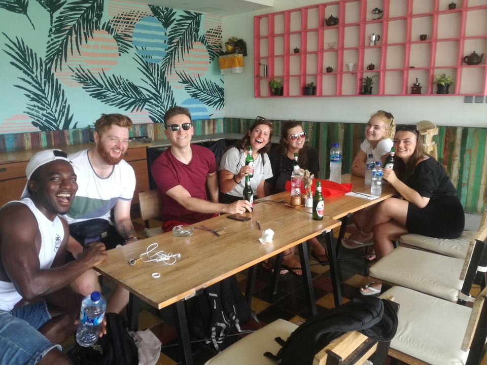 Group of people enjoying drinks at a colorful cafe.