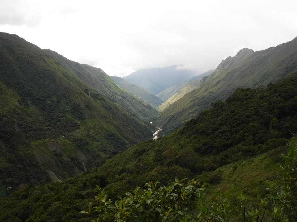 Scenic view of a lush green valley with lush hills and a winding river.