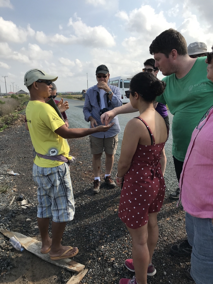 Groupe de personnes échangeant de la monnaie au bord de la route.