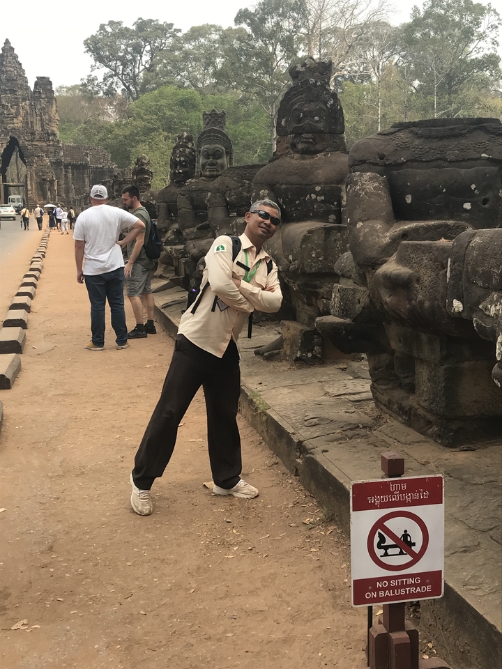 Guide touristique posant près d'anciennes structures en pierre.