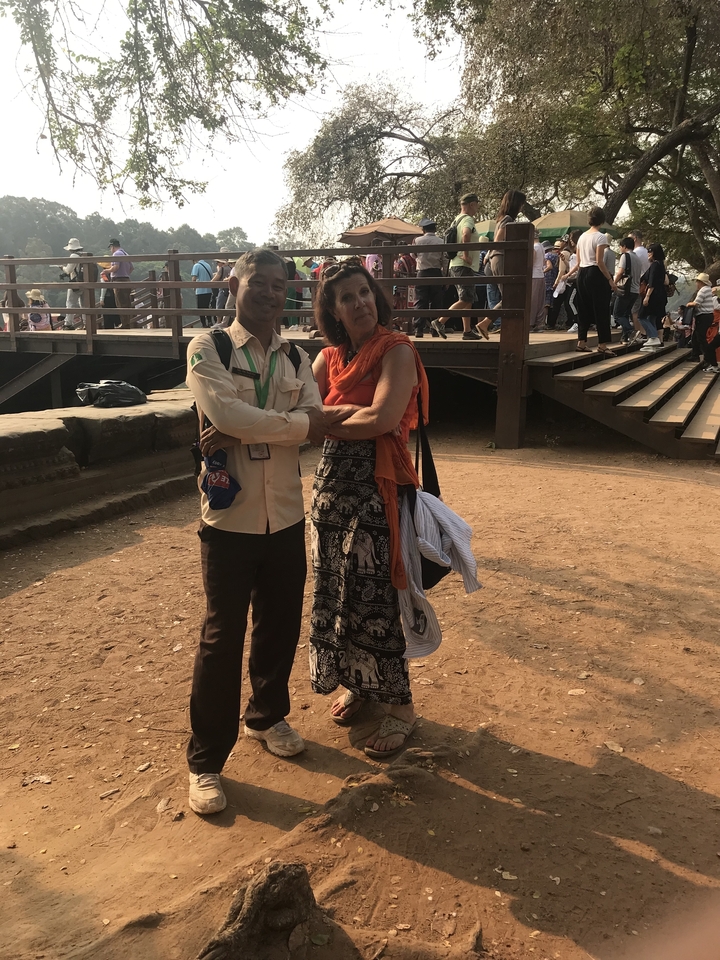 Deux personnes qui posent sur un site touristique avec un arrière-plan sablonneux.