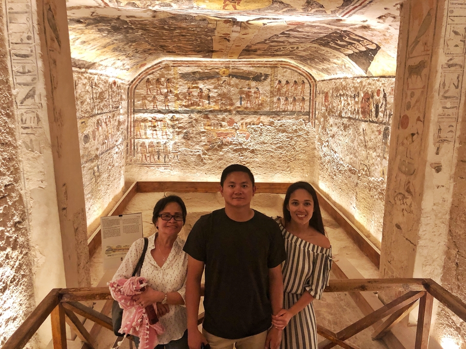 Family inside an ancient tomb with hieroglyphics.