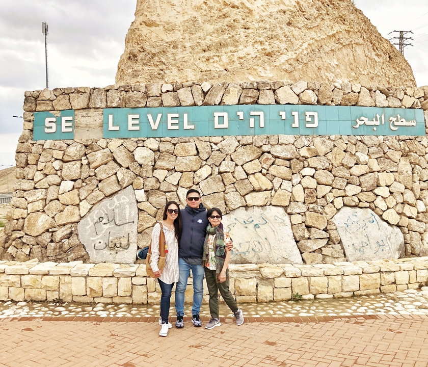 Family posing at a sea-level sign.