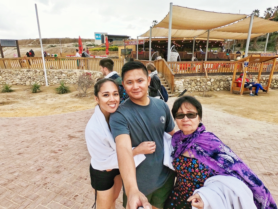 Three people posing at a sea level marker.
