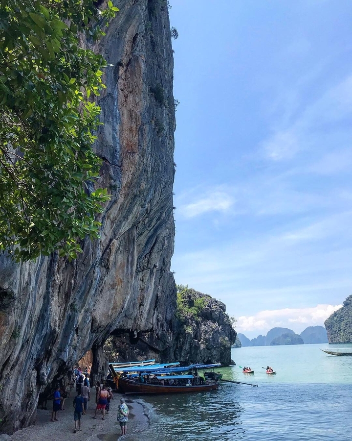 Close-up view of a cliff against a bright sky.
