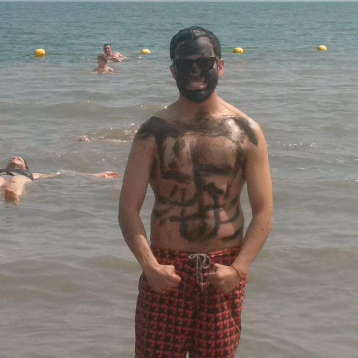 Person covered in mud standing in water