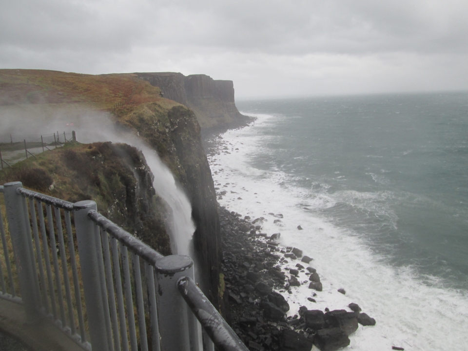 Cliffside waterfall overlooking a rough sea.