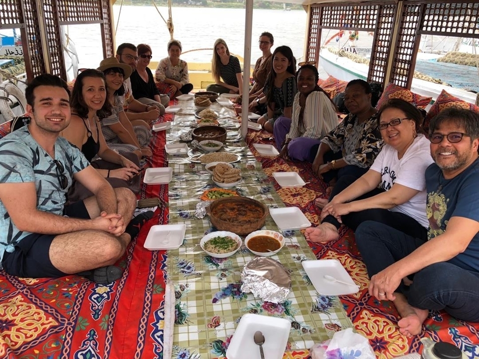 Group of people enjoying a meal on a boat.