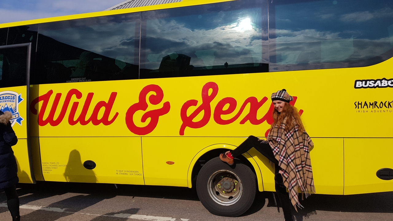 Personne posant à côté d'un autocar de tourisme avec l'inscription « Wild & Sexy ».