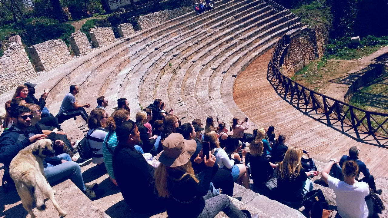 People sitting in a stone amphitheater.