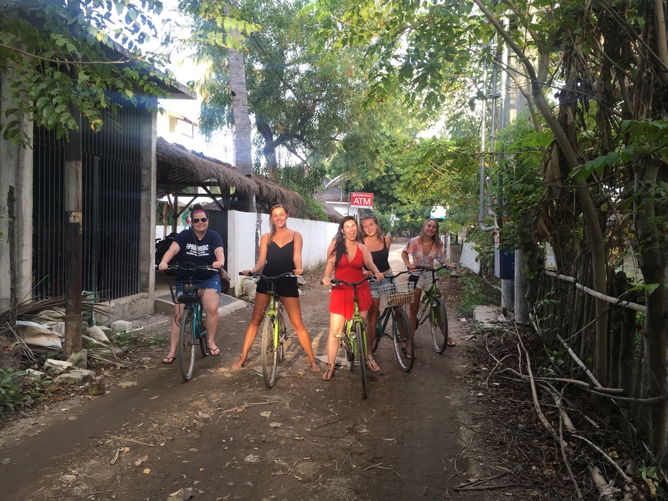 Group of friends riding bicycles along a dirt path.