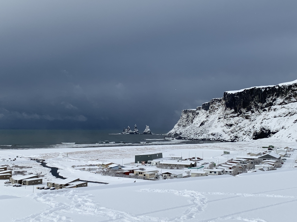 Rocky volcanic beach with dramatic sea pillars and ocean waves.