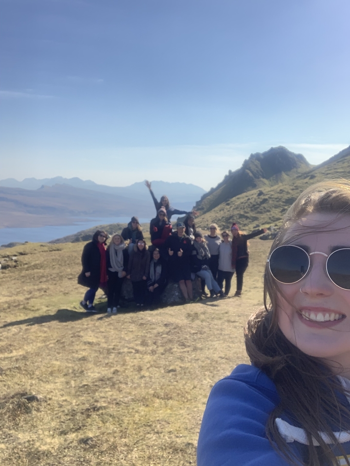 A group of people posing on a mountain ridge.