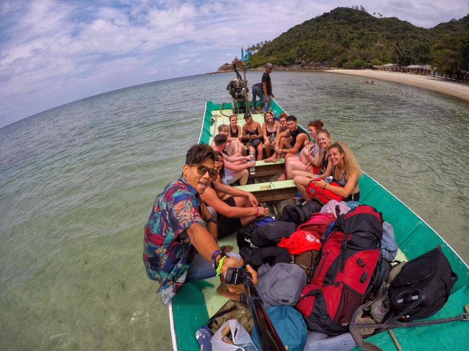 Group of people sitting in a small boat on clear waters.