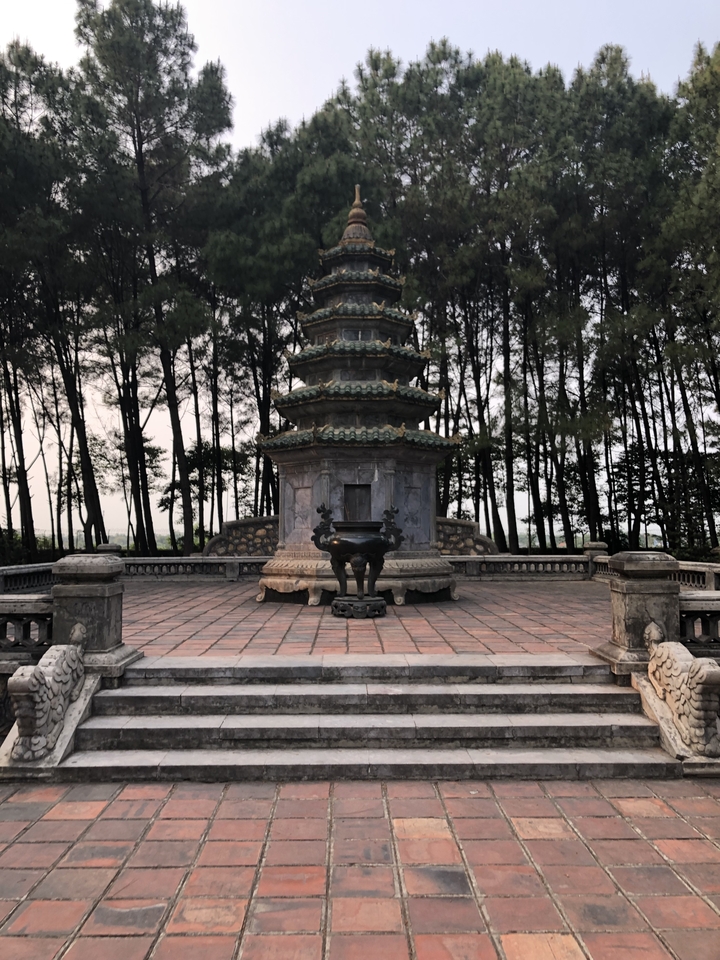 Ornate stone structure in a wooded area.