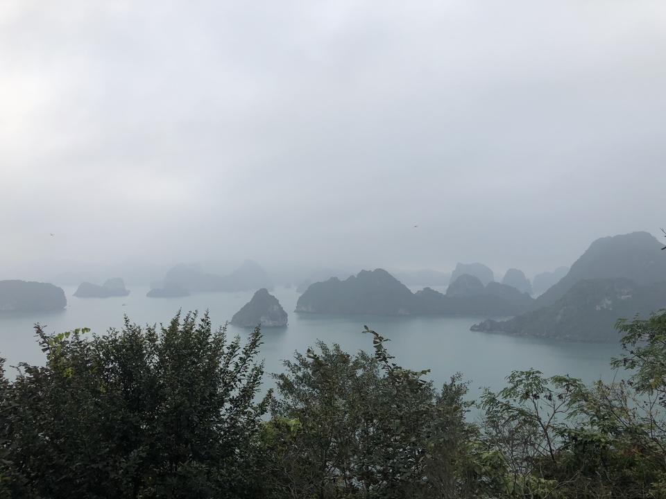 Scenic view of small rocky islands in a bay under a cloudy sky.
