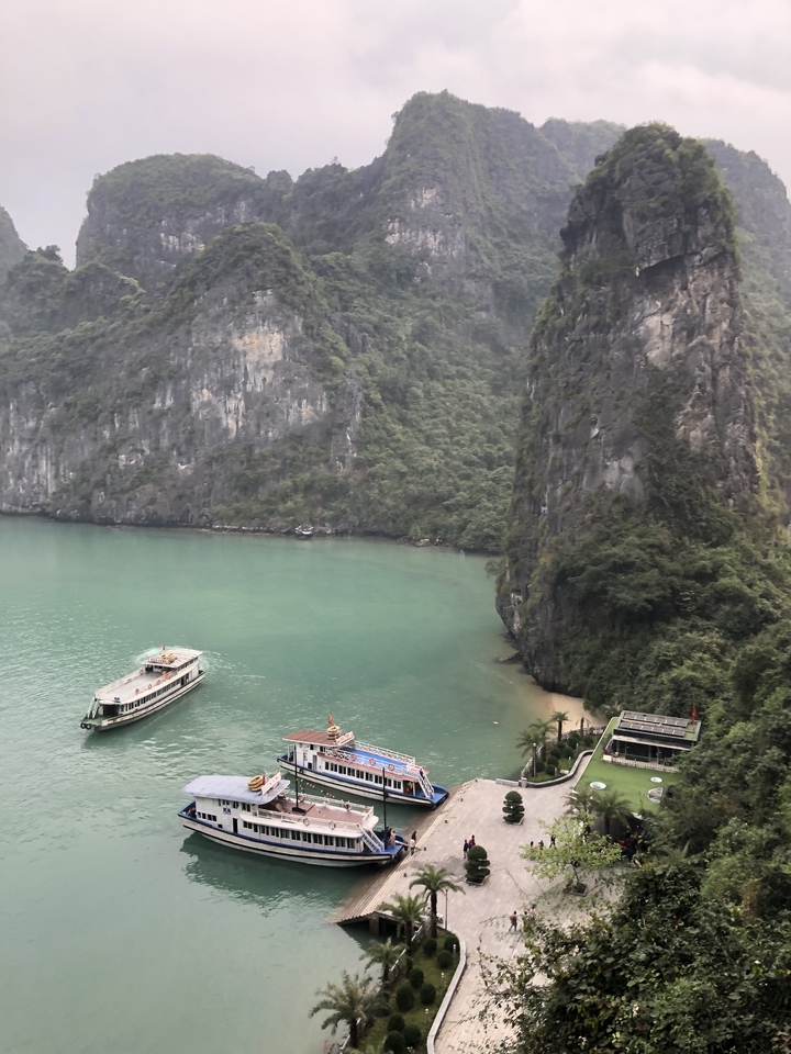 View of a boat navigating through a narrow channel surrounded by cliffs.