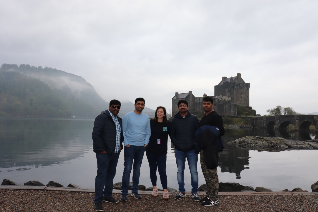 Group of people in front of Eilean Donan Castle with mist over the water.