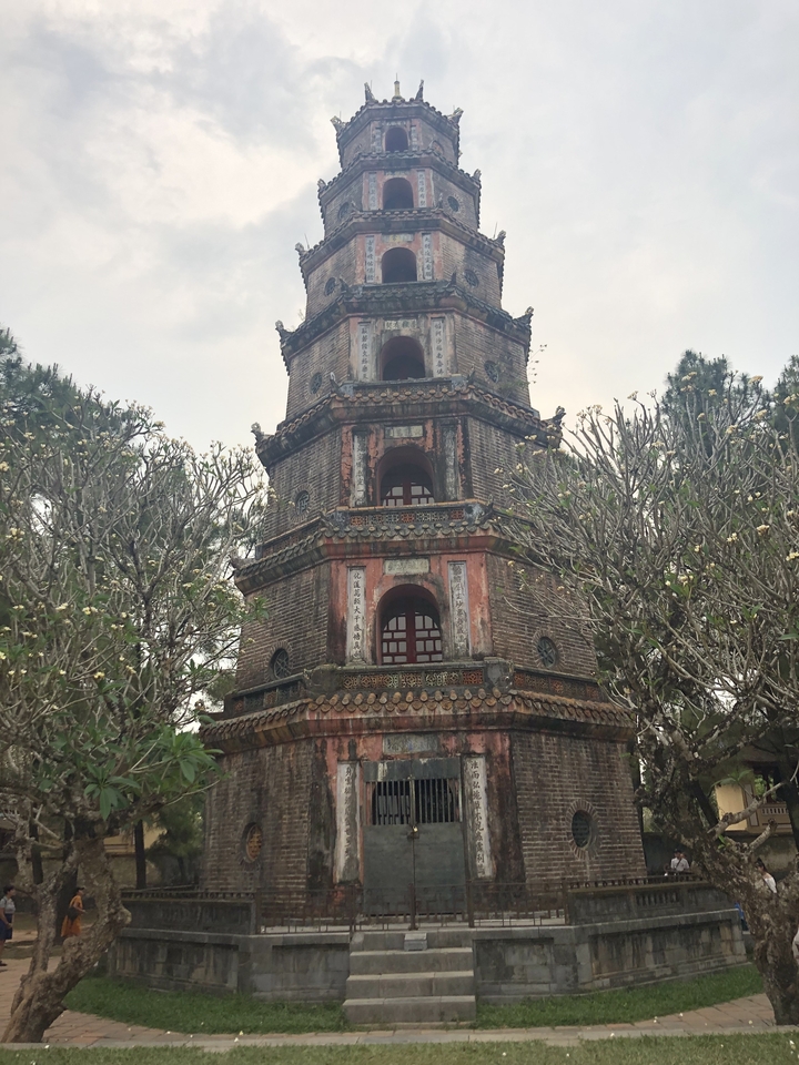 A historic, multi-storied pagoda set among trees.