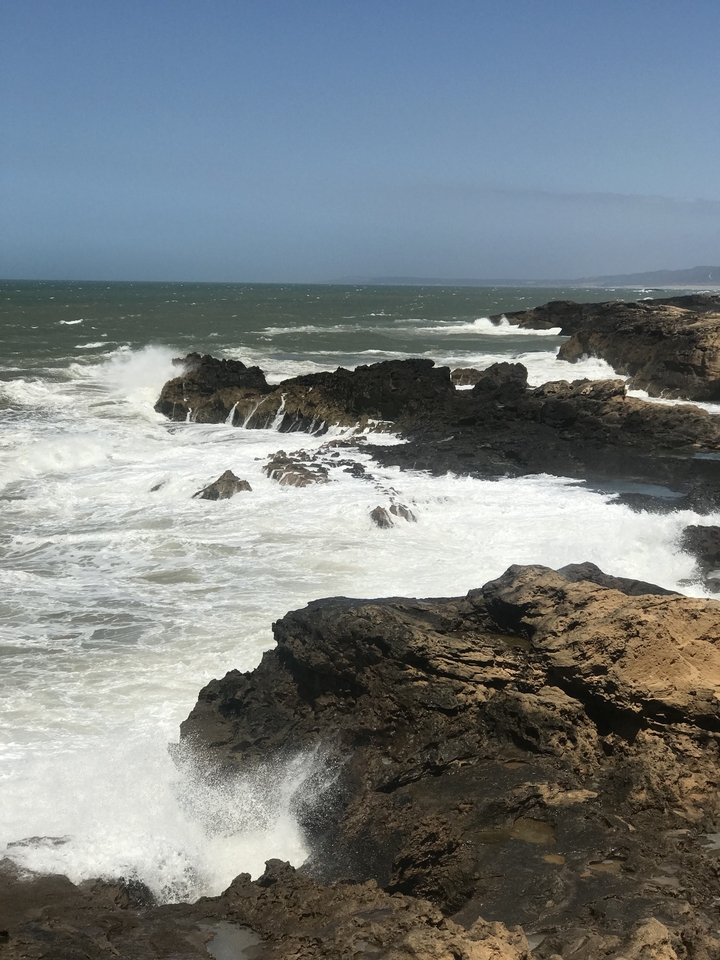 Rough sea waves crashing against rocky cliffs.