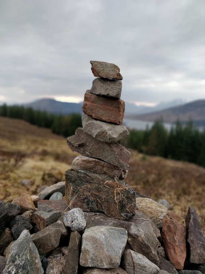 Cairn de pierres empilées dans un cadre naturel pittoresque.
