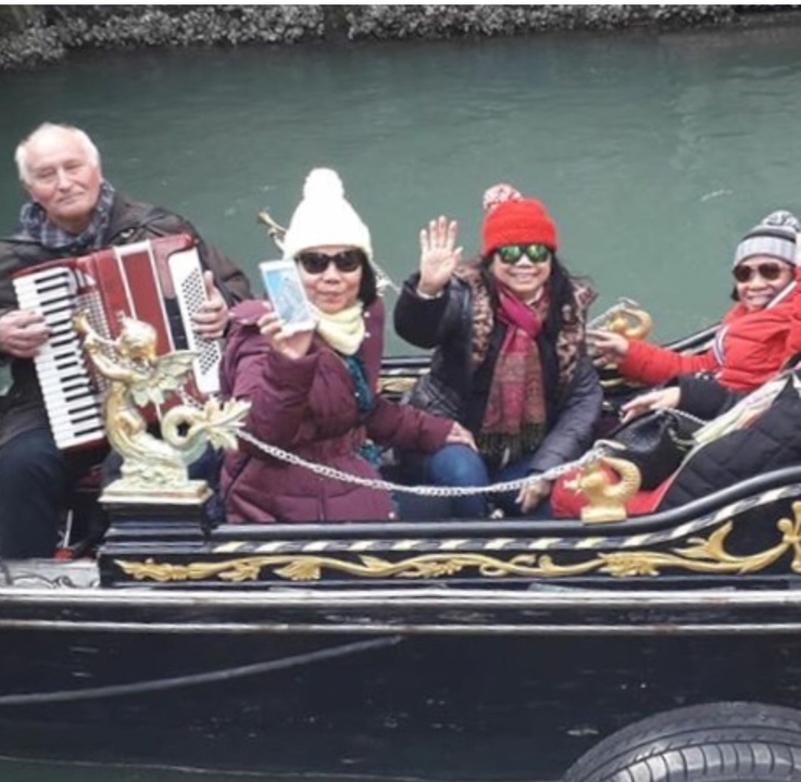 People on a gondola ride in a canal.
