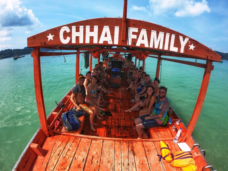 Group sitting on a boat with 'CHHAI FAMILY' sign.