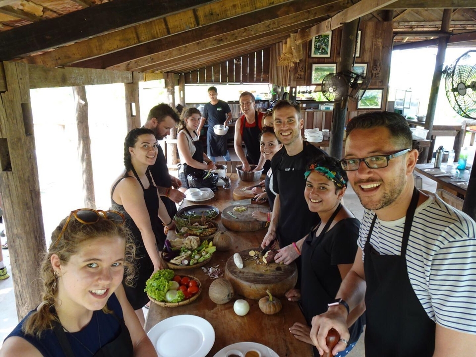 Group enjoying a cooking class, chopping vegetables.