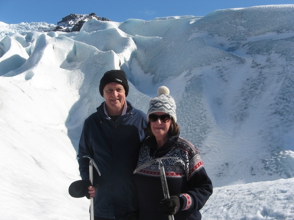 Couple posing in front of a snow-covered landscape.