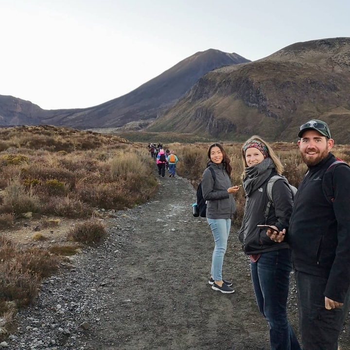 Group of hikers walking on a trail through mountainous terrain.