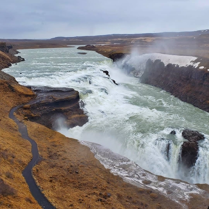 Aerial view of a powerful waterfall with mist rising.