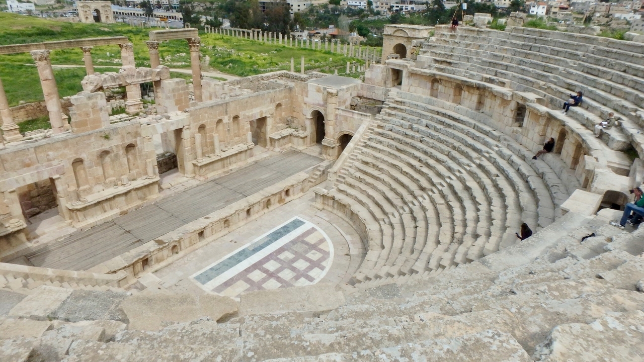 Amphithéâtre romain antique avec gradins en pierre et scène.