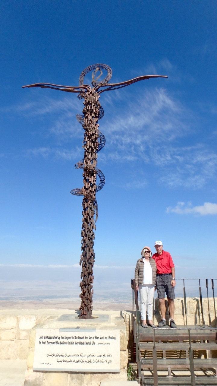 Deux personnes posant près d'une grande sculpture artistique.