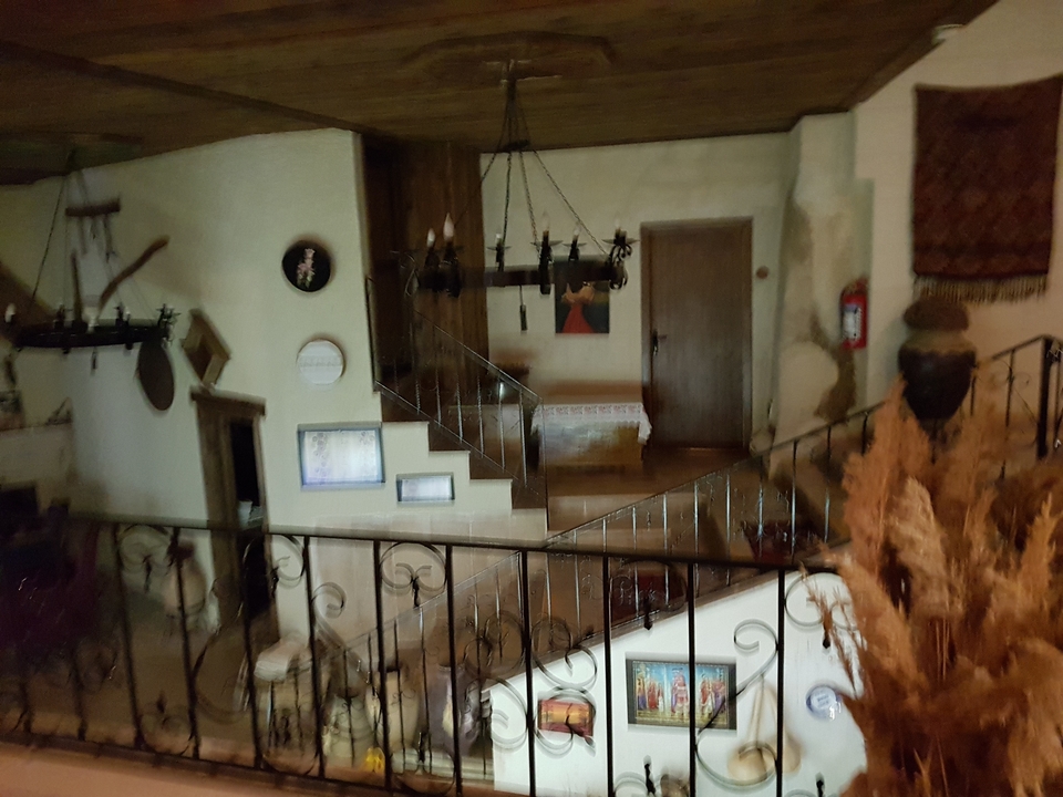 Image floue d'un intérieur rustique avec escalier et décoration murale.