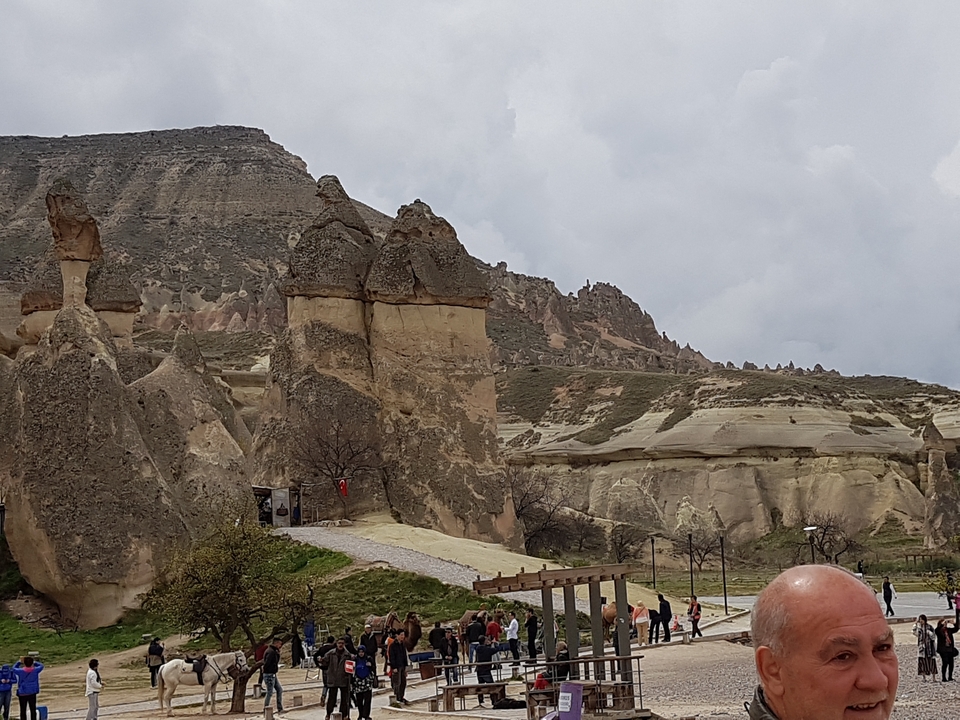 Des gens qui marchent parmi des formations rocheuses dans une vallée.
