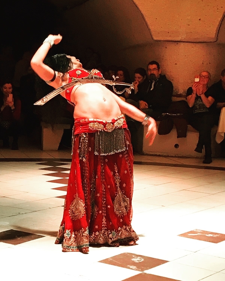 Indoor belly dance performance with traditional costume.